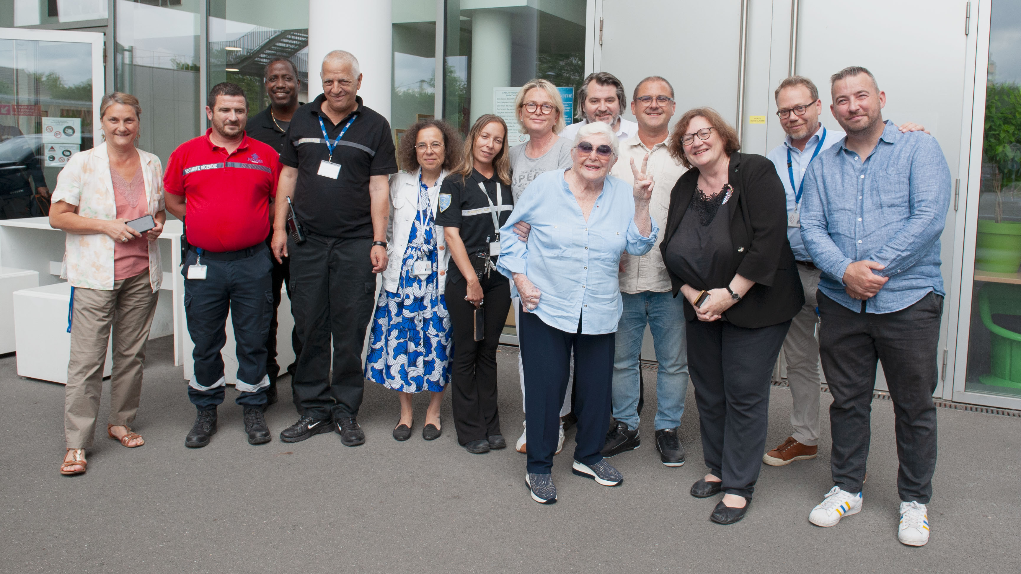 Photo de groupe, en exétieur, avec Line Renaud au millieu d'agents. 