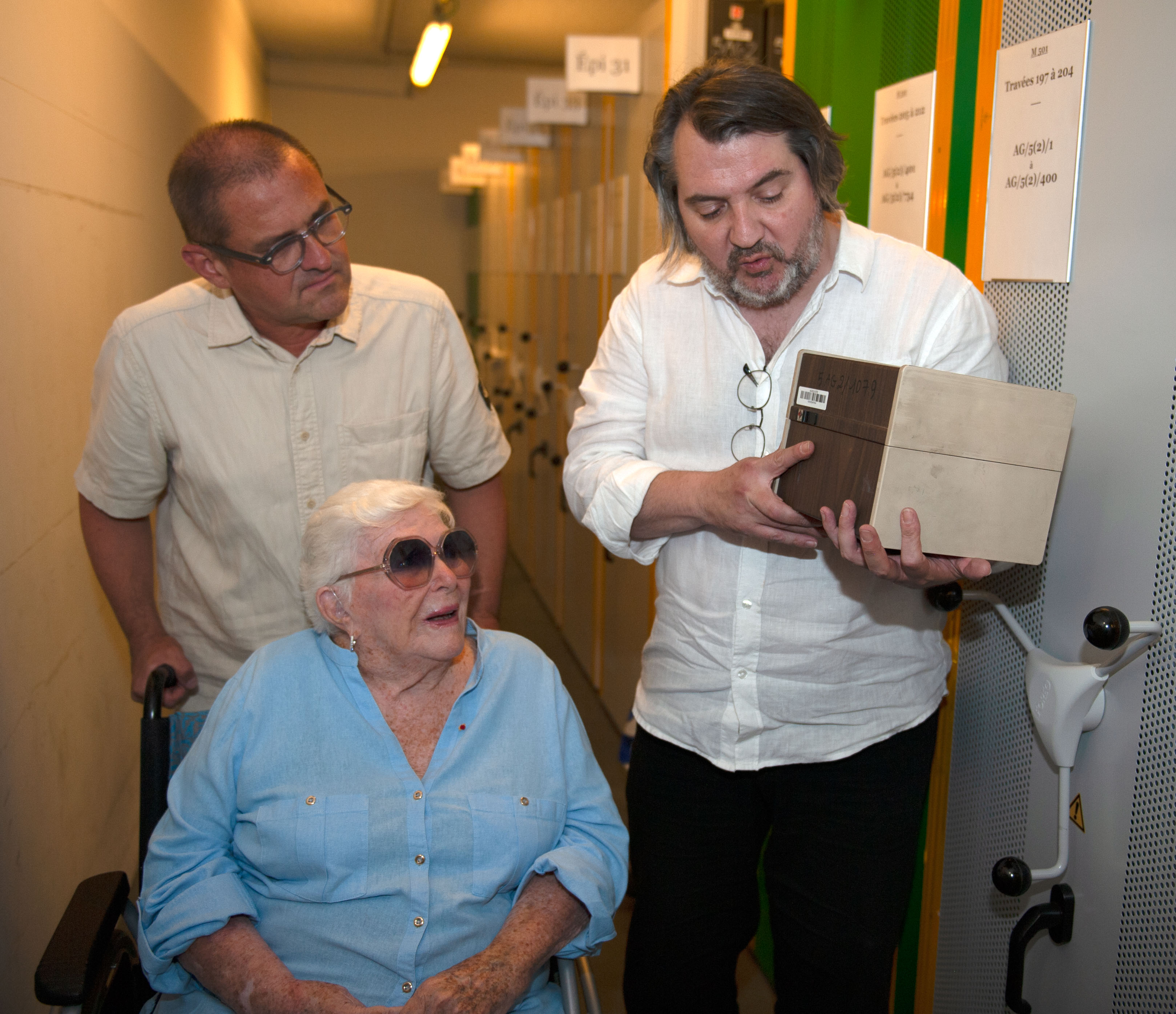  Un archiviste, présente à Line Renaud une boîte carrée, qui contient des fiches de l'Élysée.