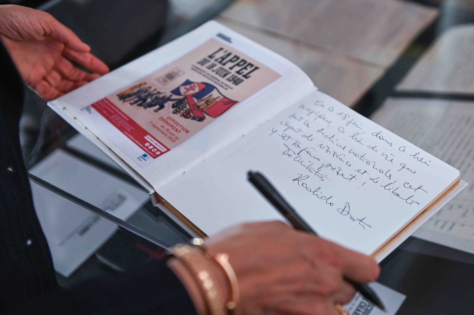 La ministre de la Culture signe un message dans le livre d'or de l'exposition. 