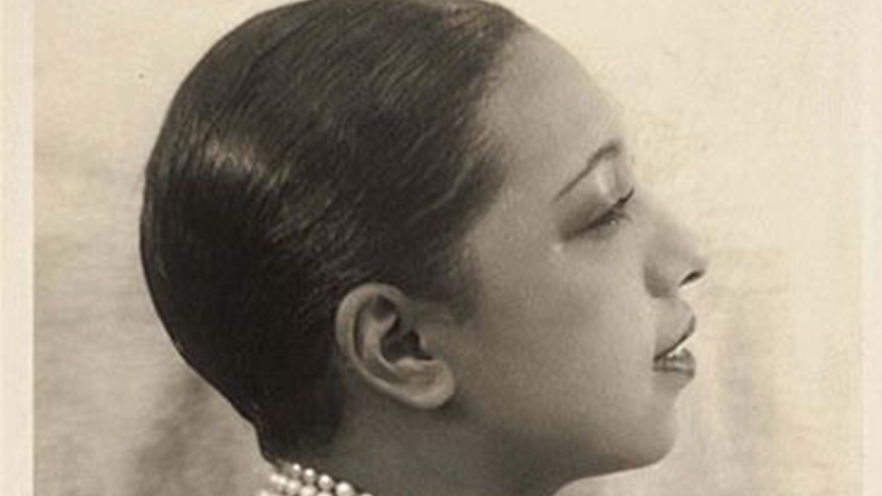 Photo en noir et blanc, en plan serré sur le visage de Joséphine Baker qui est de profil. Elle a les cheveux tr-s courts et gomminés. 