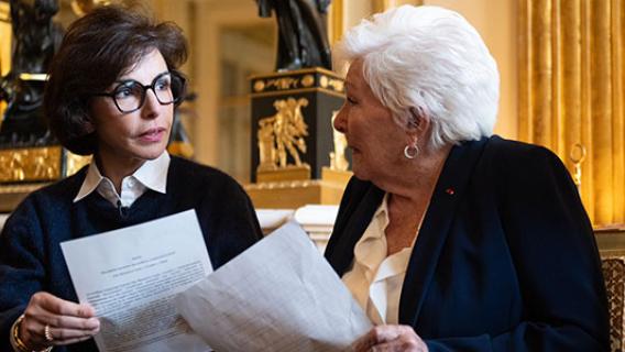 Rachida Dati, ministre de la Culture, et Line Renaud en train de discuter dans un salon doré du ministère. Elles ont des documents en main.  