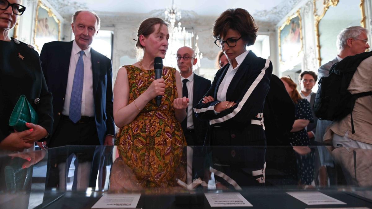 La commissaire de l'exposition présente les documents à la ministre de la Culture.
