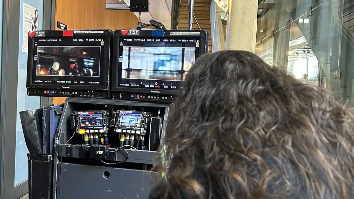 De dos, une technicienne surveille les moniteurs et le déroulé du tournage en direct. 