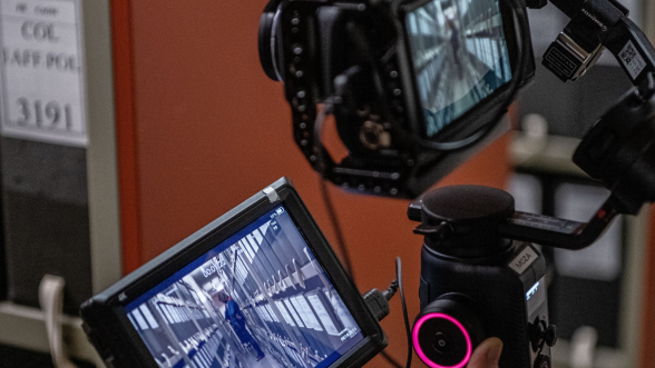 Caméraman en train de filmer un reportage dans les rayonnages des ANOM