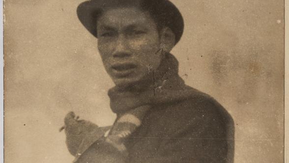 Portrait en buste et en noir et blanc d'Ho Chi Minh portant un chapeau melon et fumant une cigarette