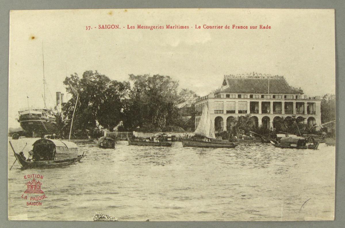 Photographie d'une baie avec a premier plan un bateau des Messagerie maritimes transportant du courrier et à l'arrière plan une ville