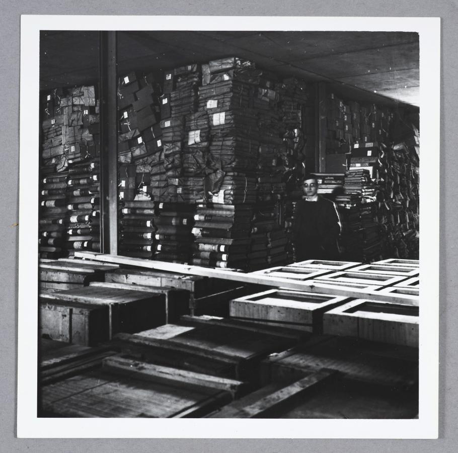 Photographie en noir et blanc représentant des caisses et paquets d’archives arrivées au Dépôt des archives d’outre-mer