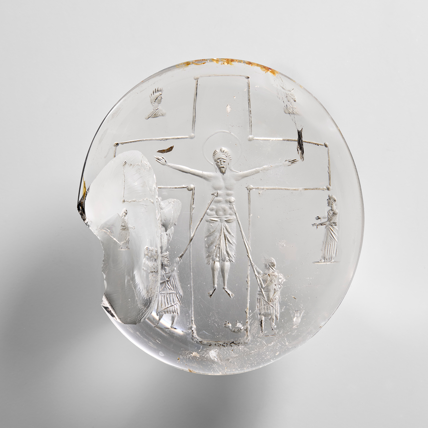 Cabochon en cristal de roche gravé : Christ en croix entre deux centurions lui perçant les flancs. Vue de face.