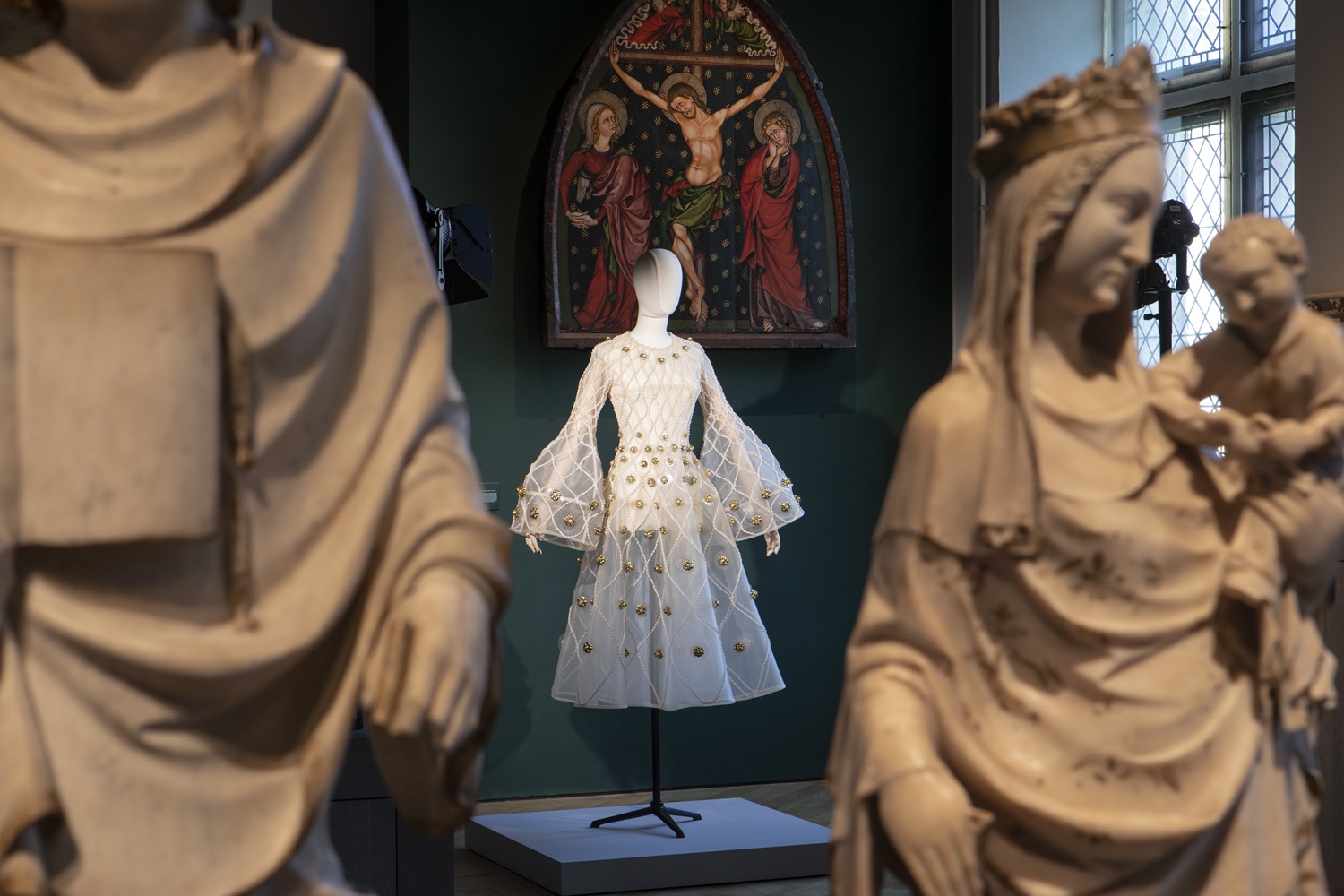 Vue d'une salle du musée avec, à l'arrière-plan, une robe blanche posée sur un mannequin
