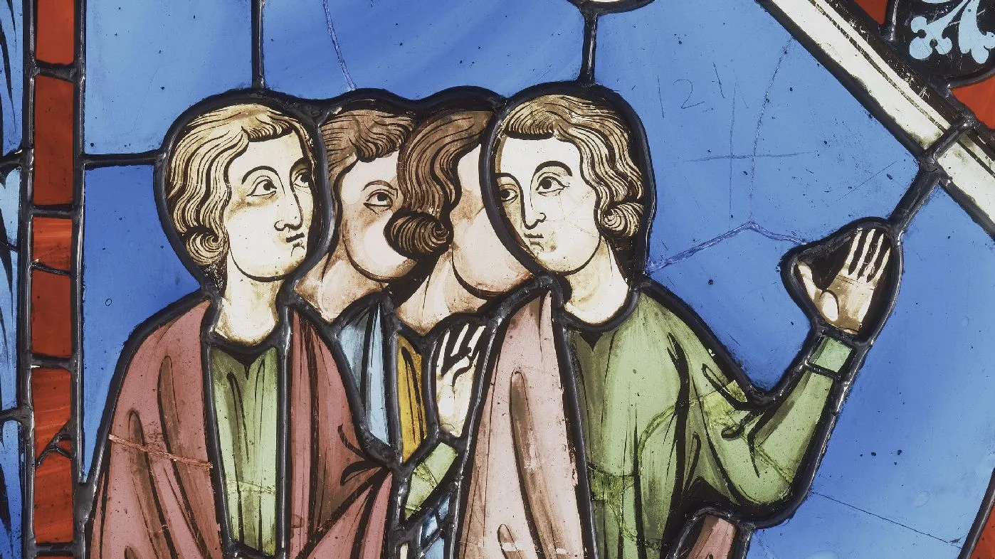 Détail d'un vitrail bleu représentant un groupe de quatre personnages masculins.