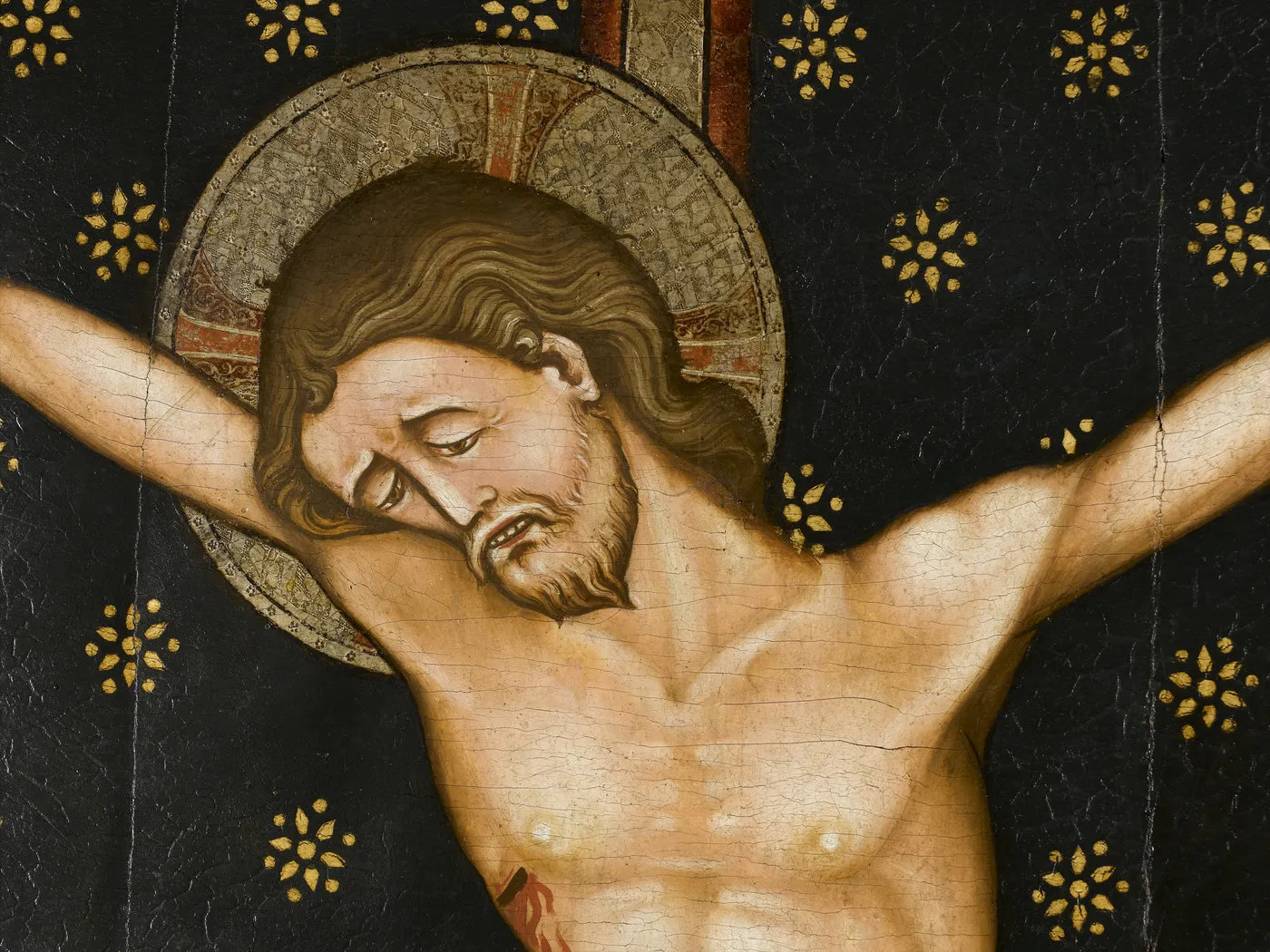 Peinture représentant le buste du Christ sur la croix, sa tête auréolée est penchée sur l’épaule droite. Vue de face.
