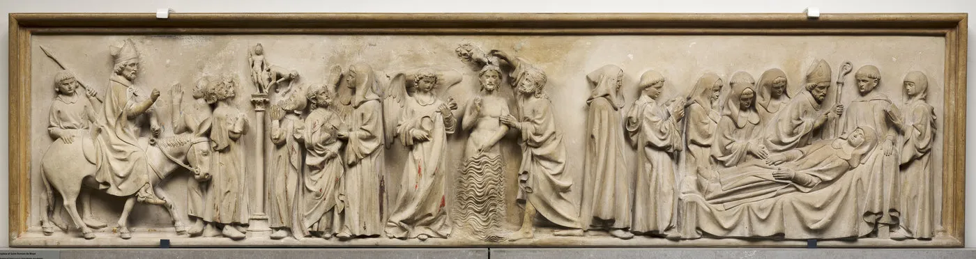 Retable sculpté en pierre avec traces de polychromie : le baptême du Christ encadré de scènes historiées. Vue de face.