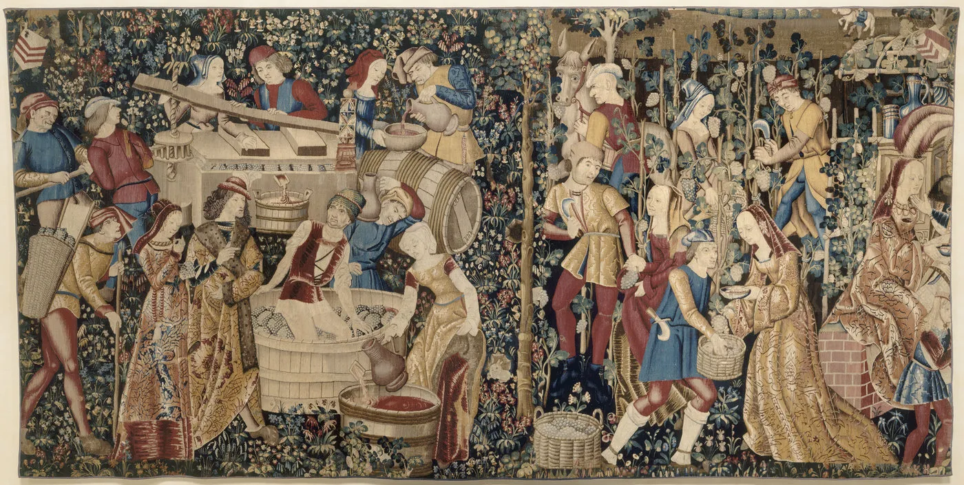 Tapisserie représentant plusieurs épisodes des vendanges. De nombreux personnages en tenue seigneuriale évoluent dans un décor de millefleurs. Vue de face. 