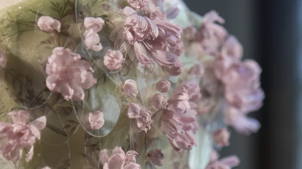 Détail d'une robe bustier brodée crème et rose 