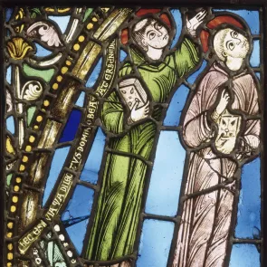 Stained glass window depicting two monks, their gaze raised towards the sky. Latin inscription on the left side. Front view.