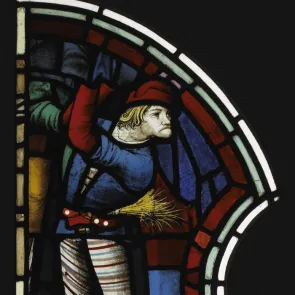 Vitrail représentant un homme avec des chausses multicolores et le visage tordu. Photographie de face sur fond neutre. 