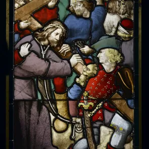Stained glass window depicting Christ carrying His cross, surrounded by figures. Front view.