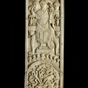 Plaque en ivoire sculptée représentant un homme sur un trône au-dessus d’une scène de combat avec des animaux. Vue de face.