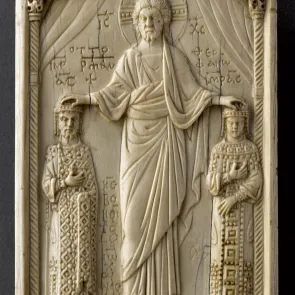 Carved ivory plaque depicting a haloed man between two figures, placing his hands on their heads. Front view.
