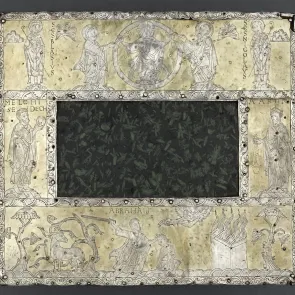 Objet rectangulaire formé d’une plaque de porphyre vert entourée d’agent gravé des motifs religieux. Photographie de face.