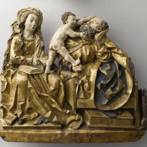 Sculpture en bois polychrome : couple assis, un enfant debout sur leurs genoux tenant le visage de l’homme. Vue de face.