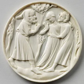 Round ivory plaque carved with a couple and a hooded, bearded figure. Frontal view.