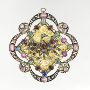 Objet métallique émaillé et ciselé orné d’un aigle incrusté de pierres et de perles. Vue de face.