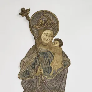 Embroidery depicting the Virgin and Child. Her face is turned downward, toward the Child. Front view on a neutral background.