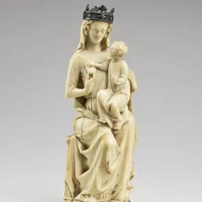 Statuette depicting the Virgin Mary with a metal crown on her head and the Infant Jesus seated on her thigh. Front view on a neutral background.