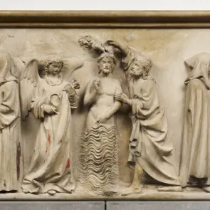 Carved stone altarpiece with traces of polychromy: the Baptism of Christ framed by historical scenes. Front view.