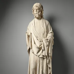 Stone sculpture of a standing apostle with a melancholic face. Front view on a neutral background.
