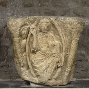 Stone capital: Christ in Majesty seated on a throne, inscribed within an almond-shaped mandorla. Front view.