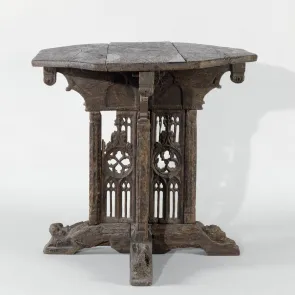 Table en bois de forme octogonale et panneaux ajourés sculptés de motifs gothiques. Vue de face.