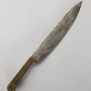 Couteau en métal au manche gravé des armoiries et de la devise de Philippe le Bon. Photographie de face.