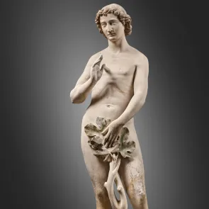 Full-length sculpture of Adam, standing with a swayed hip and nude, holding a fig leaf to cover himself. Front view photograph on a neutral background.