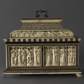 Coffret en bois orné de plaquettes d’ivoire sculpté représentant des personnages en action. Vue de face.
