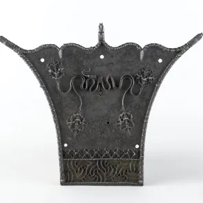 Objet métallique : serrure ornée de motifs végétaux et géométriques en relief. Vue de face.