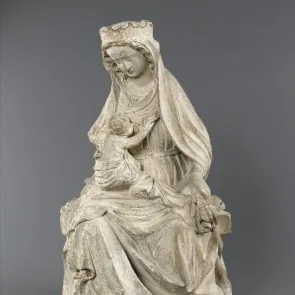 Statue en pierre d'une Vierge allaitant l'Enfant Jésus. La Vierge est assise et l'Enfant sur ses genoux. Vue de face.