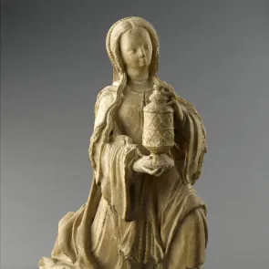 Sculpture en pierre : femme aux longs cheveux en génuflexion portant un pot à couvercle. Vue de trois quarts.