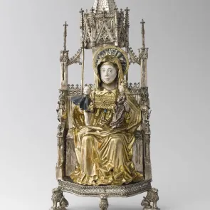 Gilded and silvered metal object: a woman on a throne, a child, and a woman with a casket on her lap. Front view.