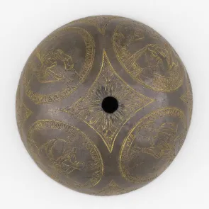 Demi-sphère en métal gravée de personnages de profil dans quatre médaillons. Photographie de face.
