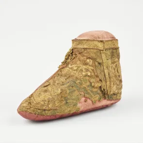Chaussure fragmentaire brodée ornée de motifs végétaux et d’animaux. Vue de trois quarts.