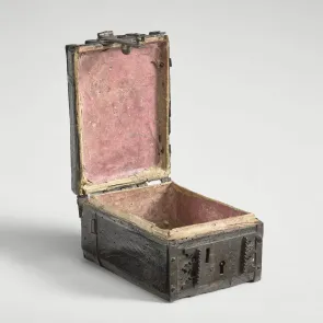 Coffret en bois et métal, présenté ouvert, avec un intérieur garni d’un parchemin rouge. Vue de trois quarts.