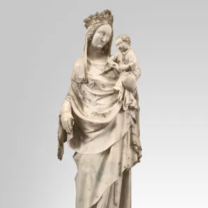 Vierge portant l'Enfant Jésus dans un bras. Statue en pied en pierre. Vue de trois-quarts sur fond neutre.