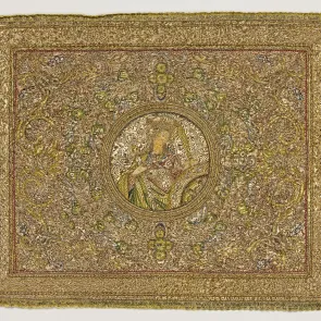 Embroidered panel: in the center, a bust of a woman holding a sword in front of a toothed wheel. Front view.