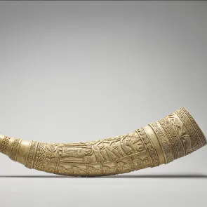 Defensa de elefante tallada y grabada con motivos figurativos y geométricos. Vista de perfil.