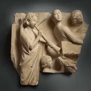 Escultura en piedra: un ángel tocando un olifante junto a personajes que salen de sus tumbas. Vista frontal.