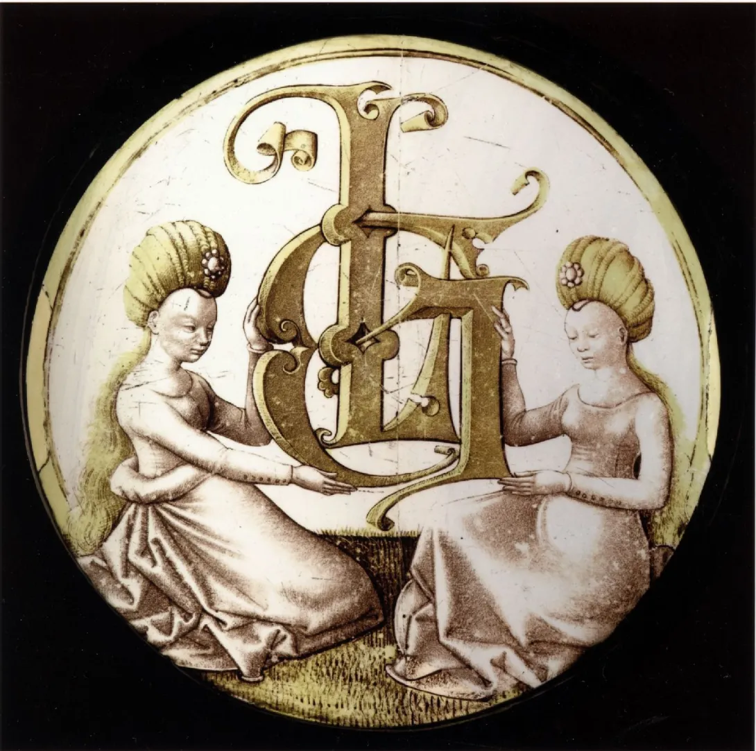 Vitrail rond jaune et gris représentant deux femmes tenant des lettrines L et G. Vue de face sur fond noir. 