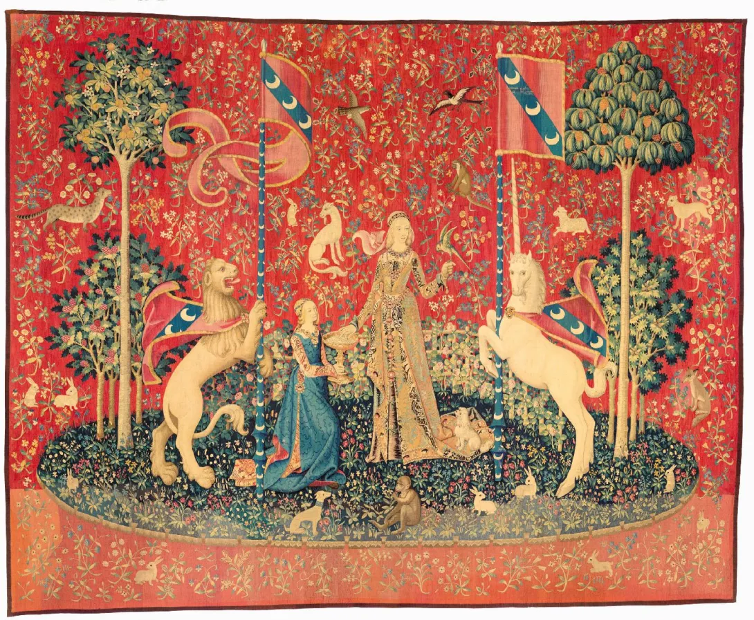 Tapisserie représentant deux femmes sur une île entre un lion et une licorne, tenant des drapeaux. Vue de face.