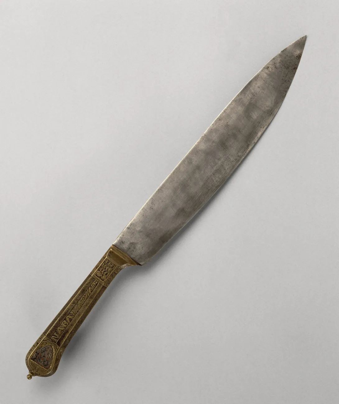Couteau en métal au manche gravé des armoiries et de la devise de Philippe le Bon. Photographie de face.